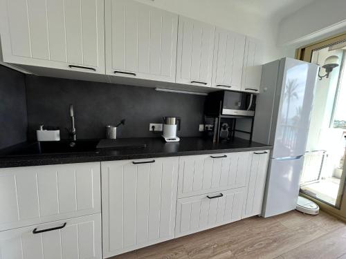 尼斯尼斯皇冠公寓的厨房配有白色橱柜和冰箱。