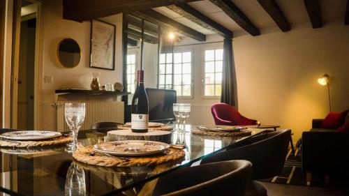 索恩河畔沙隆Le Sommelier Chalon的用餐室配有带1瓶葡萄酒的桌子