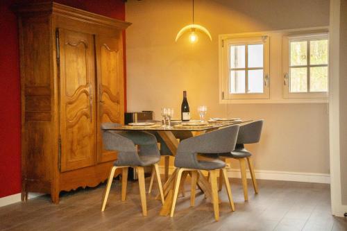 索恩河畔沙隆Le Sommelier Chalon的餐桌、椅子和一瓶葡萄酒