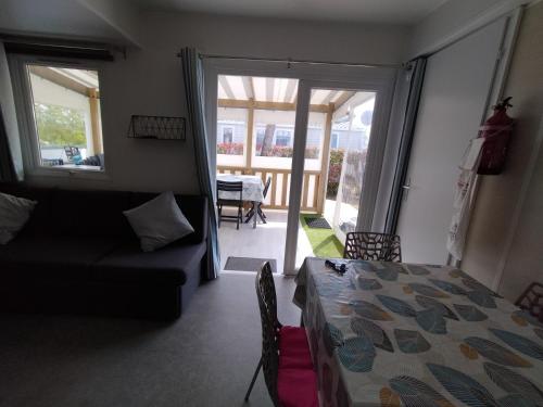 圣让-德蒙Mobil home Vendée的一间卧室配有一张床和一张沙发,并设有一个阳台
