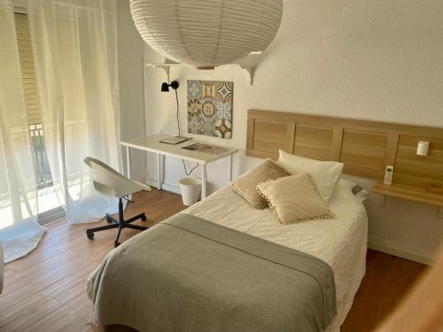 EspinardoGuest house Croqueta Espinardo的一间卧室配有一张带桌子和椅子的床