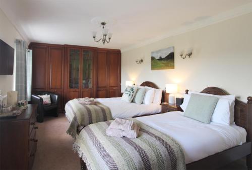霍特惠斯尔Bridge House的酒店客房,配有两张床和椅子