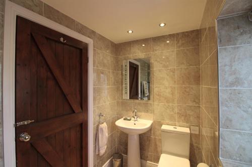 霍特惠斯尔Bridge House的一间带水槽、卫生间和镜子的浴室