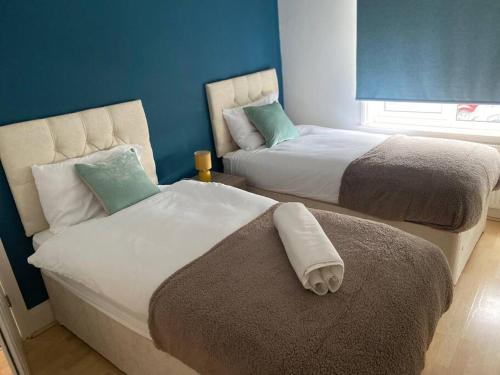 纽尼顿Amazing 4 bed Contractor hub的蓝色墙壁客房的两张床