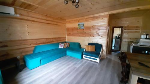 萨帕雷瓦巴尼亚Вила ВлаиДа的小屋内带蓝色沙发的客厅