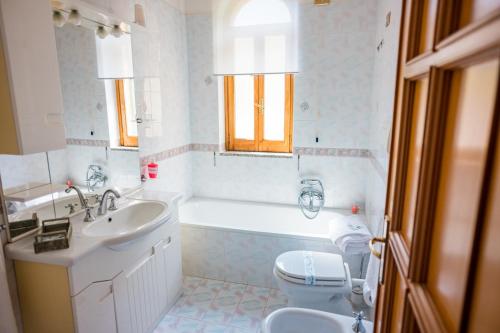 特拉蒙蒂Villa Bianca的带浴缸、盥洗盆和卫生间的浴室