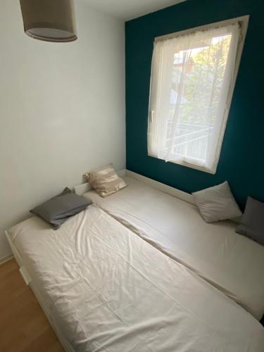 巴涅尔-德吕雄Appartement jusqu'à 4 personnes的窗户客房内的一张白色床