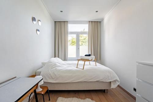 安特卫普Ruime woning in een leuke buurt nabij het centrum的一间卧室配有一张带书桌的床和窗户。