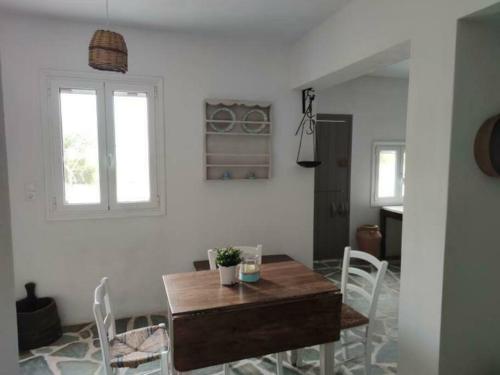 加里尼Anna's Cottage Home的一间带木桌和白色椅子的用餐室