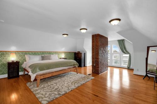 哥伦布Urban Loft 2-story 1BR Near DT on Historic Street的一间卧室配有一张床,铺有木地板。