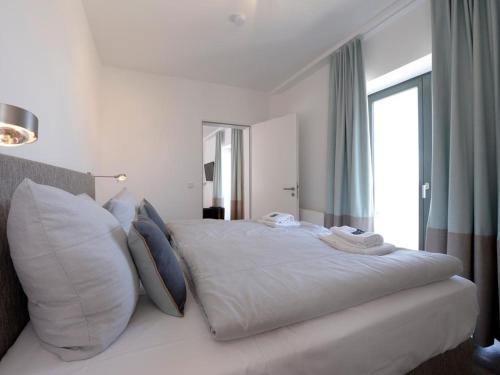 维斯马Ohlerich Speicher App. 19 - Meerblick的白色卧室配有一张带枕头的大白色床