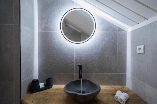 博福特Hôtel Maison Doron的一间带石制水槽和镜子的浴室