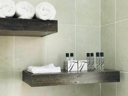 LobatseLekuka Guesthouse的浴室里的架子上装有毛巾