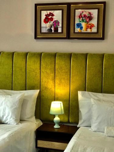 LobatseLekuka Guesthouse的配有绿色床头板的酒店客房内的两张床
