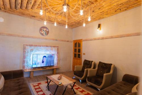 于尔居普Harmony Houses Cappadocia的客厅配有沙发、椅子和电视