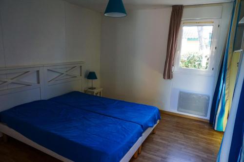 苏斯通Villas du lac的一间卧室设有蓝色的床和窗户。