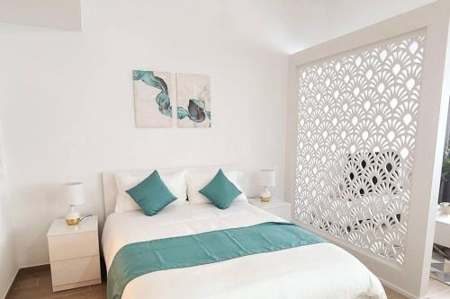 阿布扎比Luxury apartment in Yas Island的白色卧室配有蓝色枕头的床