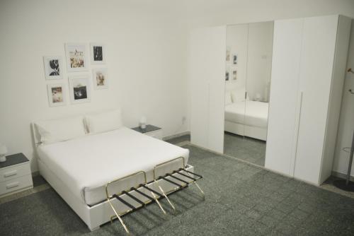 布林迪西La Casa di Eva的白色卧室配有床和镜子