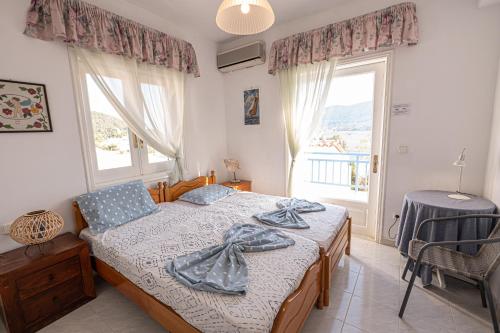 波罗斯Rigos House at Askeli beach, Poros island的一间卧室设有一张床和一个大窗户