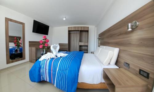 阿雷基帕Hoteles Gutiérrez Mansión的卧室配有蓝色和白色的床和一张桌子