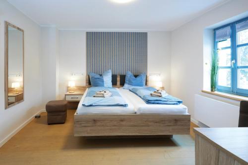 ThallwitzPension "Zum Reußischen Hof"的一间卧室配有一张带蓝色枕头的大床