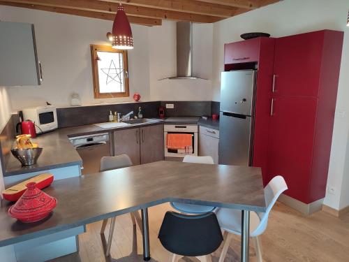 RullyLe Clos du Château的厨房配有桌子和红色冰箱