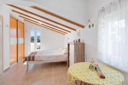 木洛希尼Apartments Čikat Mali Lošinj的一间卧室配有一张床和一张桌子