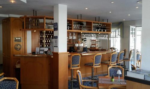 格洛韦格尼海景酒店的餐厅周围设有酒吧,周围设有椅子