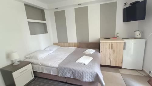 库瑞尼卡慕斯卡Noclegi, pokoje na Piaskach的一间卧室配有一张带白色床单的床和电视。