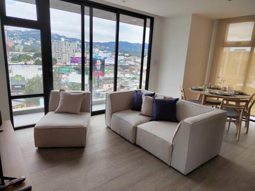 危地马拉Hermoso apartamento nuevo en zona 10!的客厅配有2张白色沙发和1张桌子