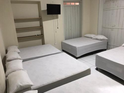 卡罗莱纳Pousada Villa Rica的一间设有两张床和一台电视的房间