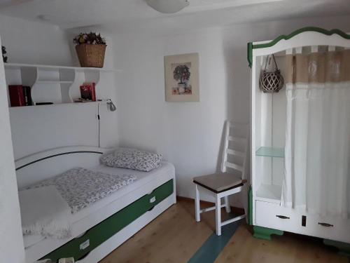 岑平Cottage, Zempin的一间小卧室,配有一张床和一把椅子