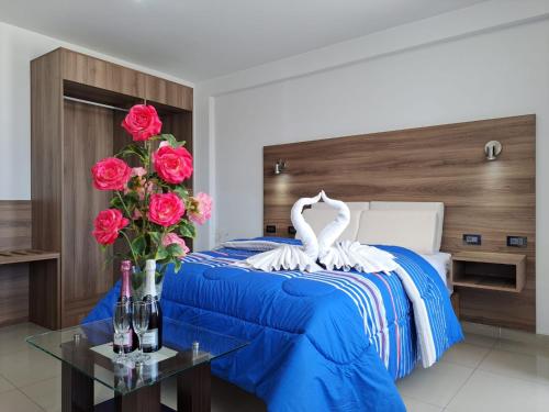 阿雷基帕PRIVATE ROOMS / DOWNTOWN AREQUIPA的一间卧室配有一张蓝色的玫瑰床和天鹅