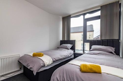 伊斯特伍德Modern flat in Eastwood Town centre的带窗户的客房内的两张床
