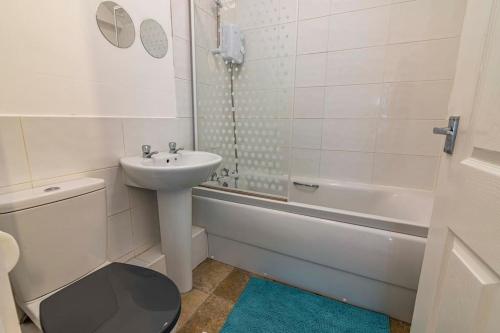 伊斯特伍德Modern flat in Eastwood Town centre的浴室配有盥洗盆、卫生间和浴缸。