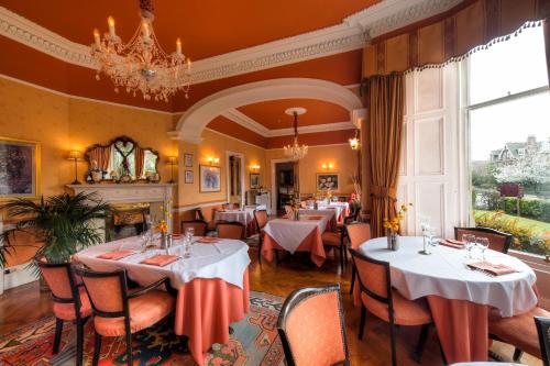 爱丁堡吉尔多南住宿酒店的一间带桌椅和吊灯的餐厅