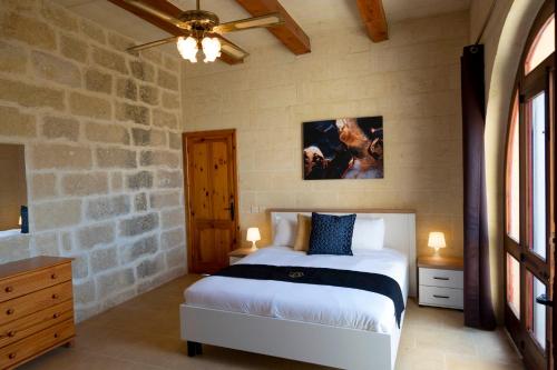 加拉VillaNirvana的一间卧室设有一张床和石墙