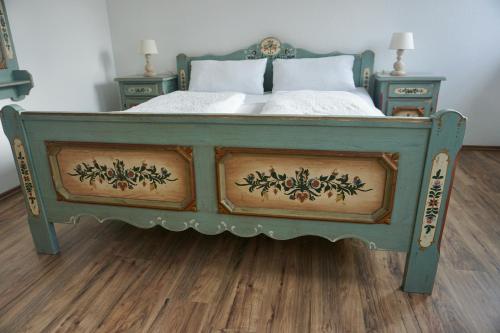 文斯托夫Landhotel Strandallee的一张绿色的床,有2个床头柜和2张桌子