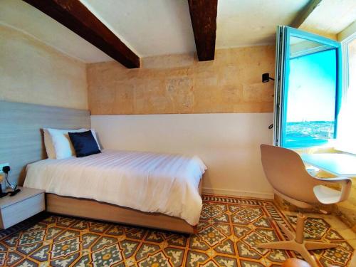 瓦莱塔Cove 532 by Savynomad Harbour Residences wow View的卧室配有床、椅子和窗户。