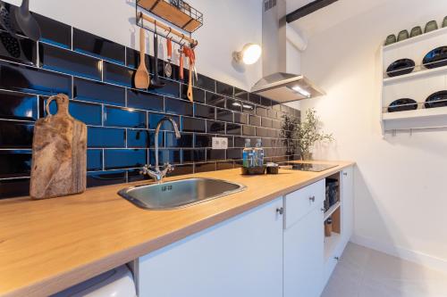 梅里达Apartamento Turístico ALHMA HOME的厨房设有水槽和蓝色瓷砖墙。