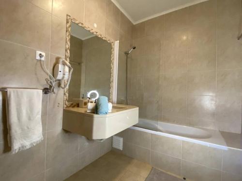 阿尔沃尔Golf Villa Alvor By CORAL的一间带水槽、浴缸和镜子的浴室