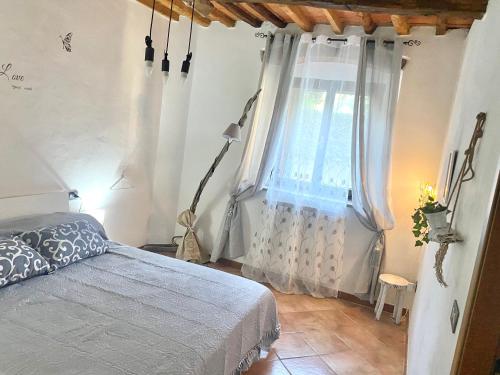 UsiglianoB&B L'angolino的一间卧室设有一张床和一个窗口