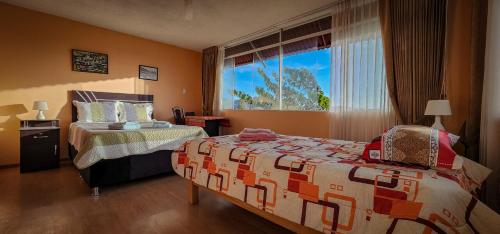 阿雷基帕Casa huerta Stuber的一间卧室设有两张床和大窗户