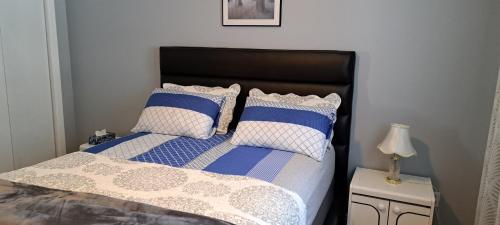 加蒂诺Bédard的一间卧室配有一张带蓝色和白色枕头的床
