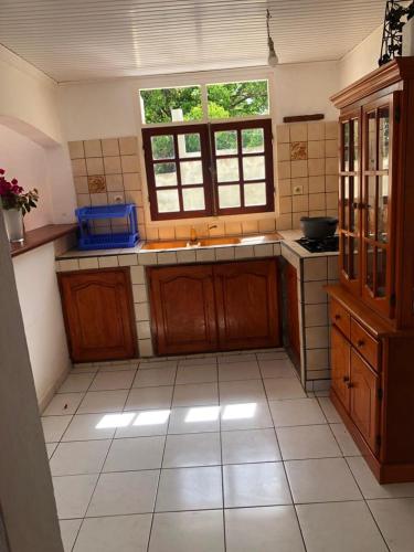 圣安尼Aka Kikine的厨房配有木制橱柜和瓷砖地板。