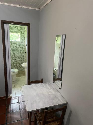 莫雷蒂斯Pousada do colono的一间带桌子、卫生间和镜子的浴室