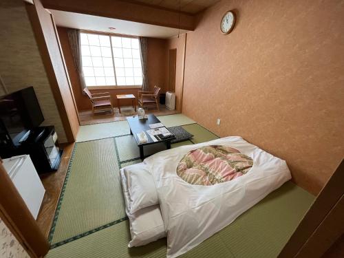 纹别市纹别太子酒店的一间设有一张床和墙上一个时钟的房间
