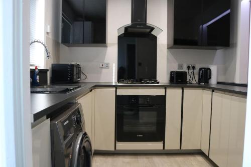 雷丁Lovely flat with Wi-Fi and free parking的厨房配有炉灶和洗衣机。