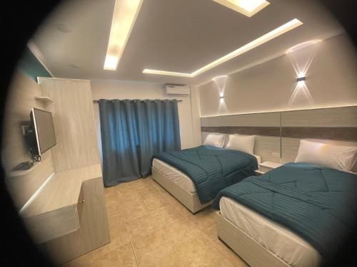 亚喀巴Al Deyafa Hotel的酒店客房设有两张床和电视。