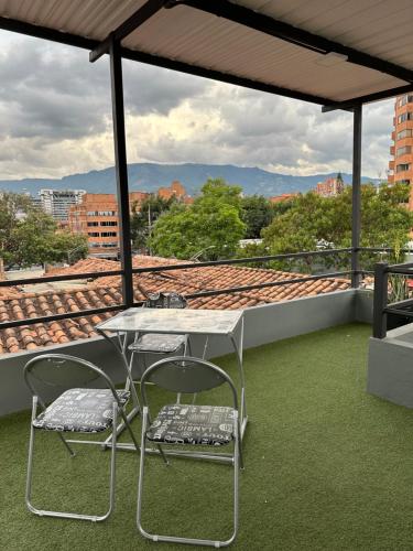 麦德林Aparta estudio amoblado 3 Medellin, San joaquin的屋顶上的一张桌子和两把椅子